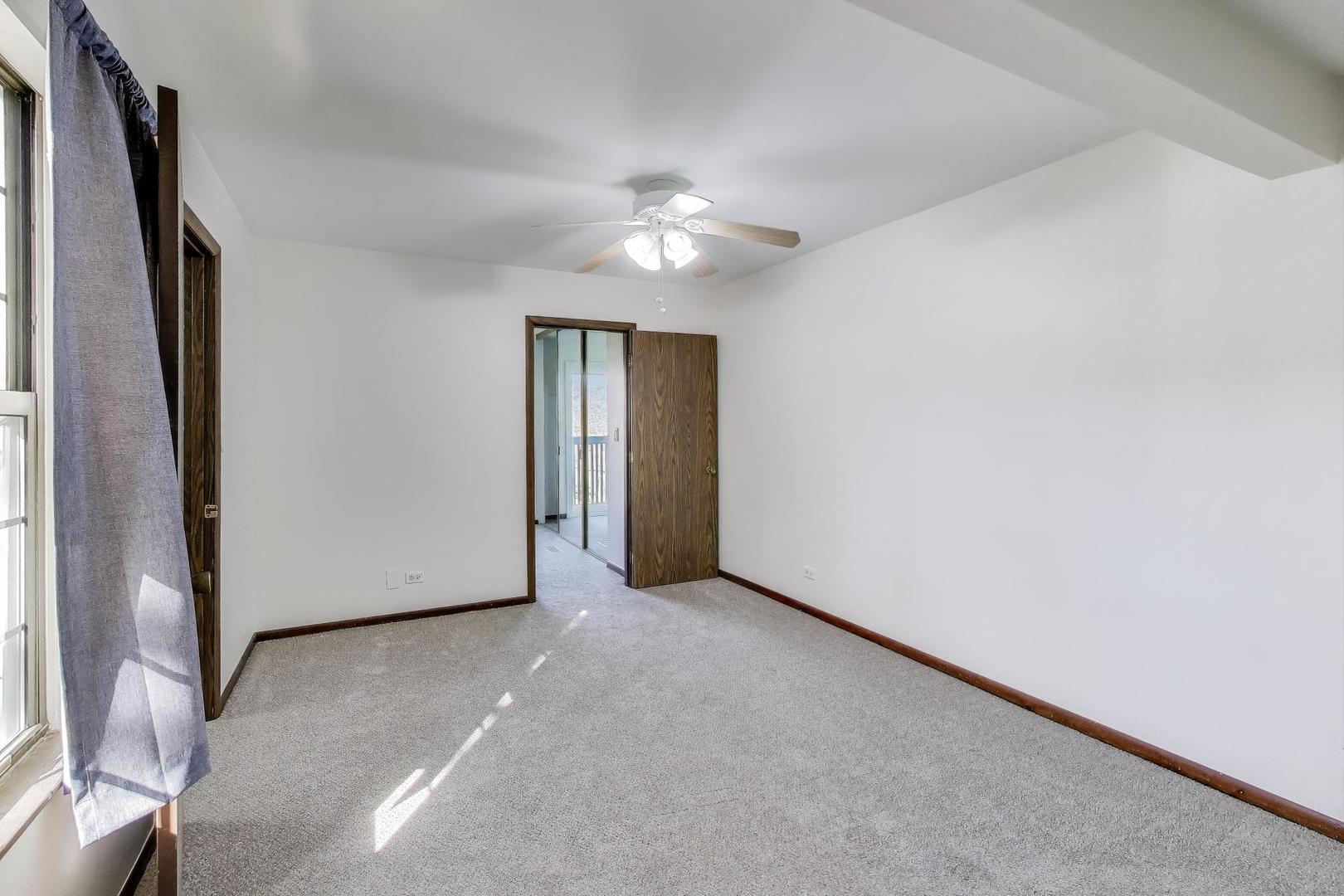 740 Chandler Road Gurnee, IL 60031 - Photo 13 of 26 an empty room with closet and a chandelier fan