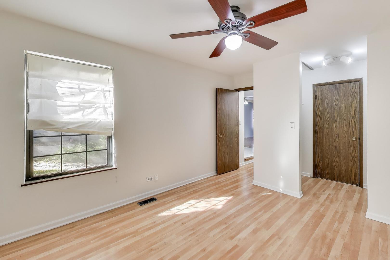 740 Chandler Road Gurnee, IL 60031 - Photo 8 of 26 a view of an empty room with window and wooden floor