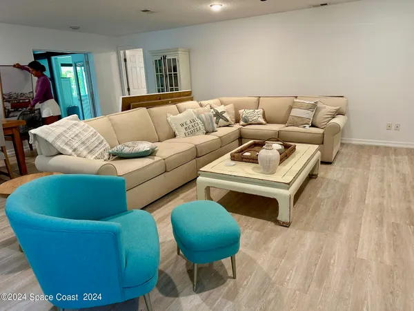 a living room with furniture and a wooden floor