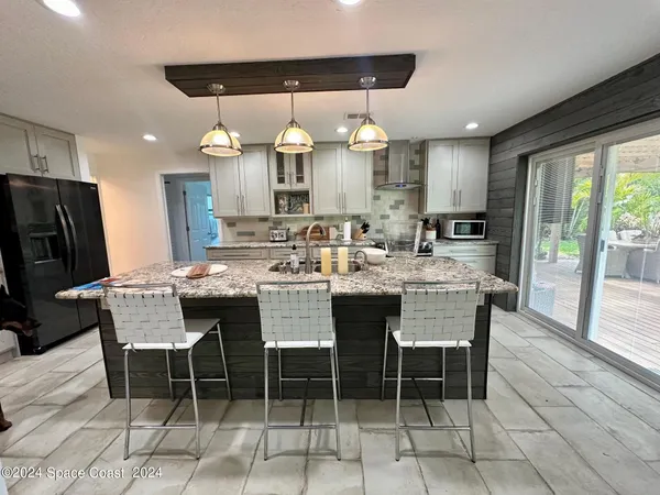 a dining hall with stainless steel appliances a dining table and chairs