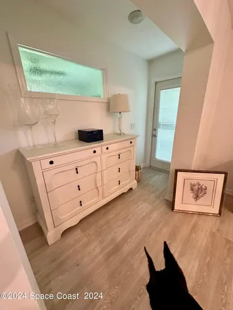 a kitchen with white cabinets and wooden floor