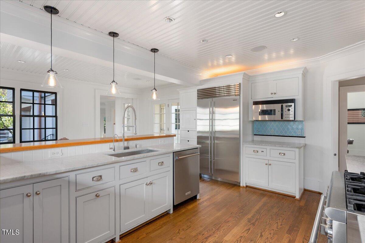 2412 Beechridge Road Raleigh, NC 27608 - Photo 9 of 39 a kitchen with white cabinets and sink