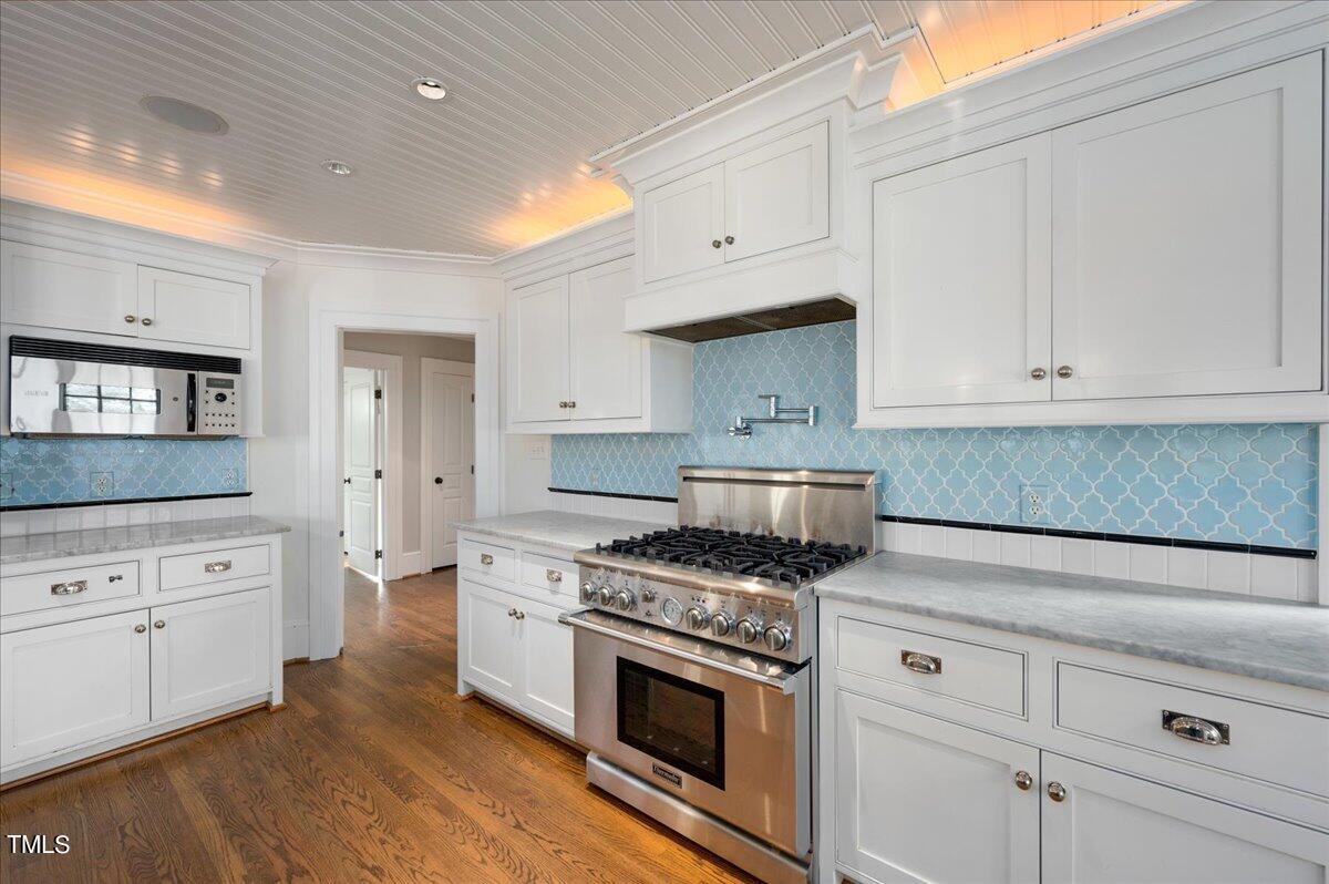 2412 Beechridge Road Raleigh, NC 27608 - Photo 10 of 39 a kitchen with granite countertop white cabinets and white appliances