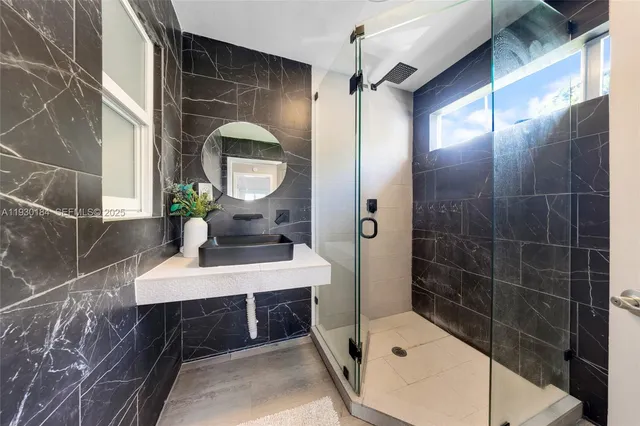 a bedroom with a bed paintings on the wall and a window