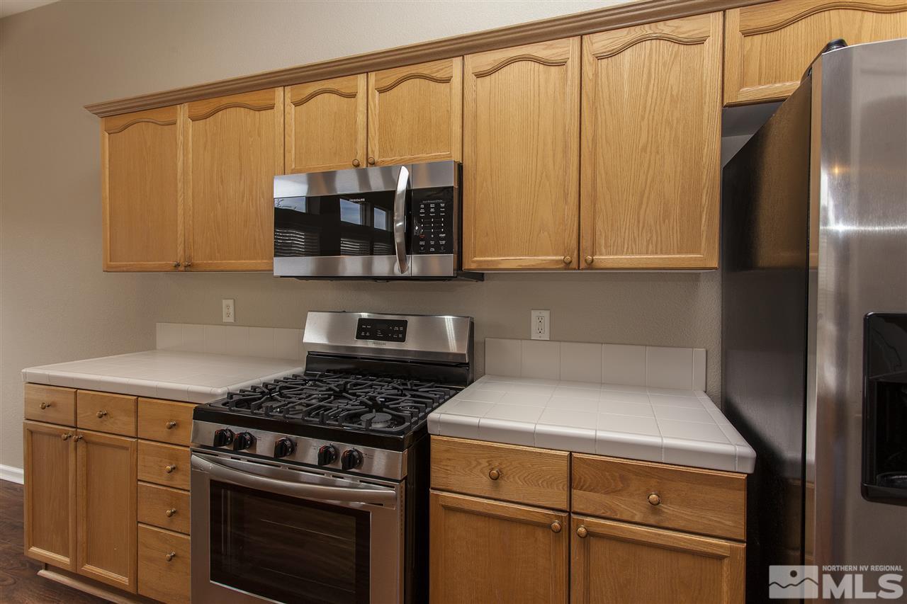 10430 Arbor Way Reno, NV 89521 - Photo 12 of 25 a kitchen with stainless steel appliances granite countertop a stove a refrigerator and a microwave