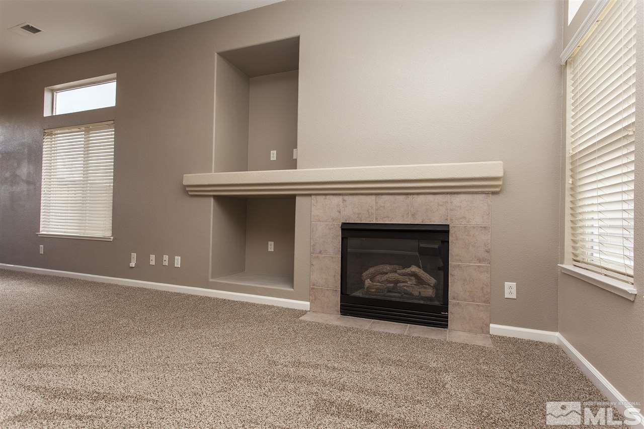 10430 Arbor Way Reno, NV 89521 - Photo 6 of 25 a view of an empty room with a fireplace and a window