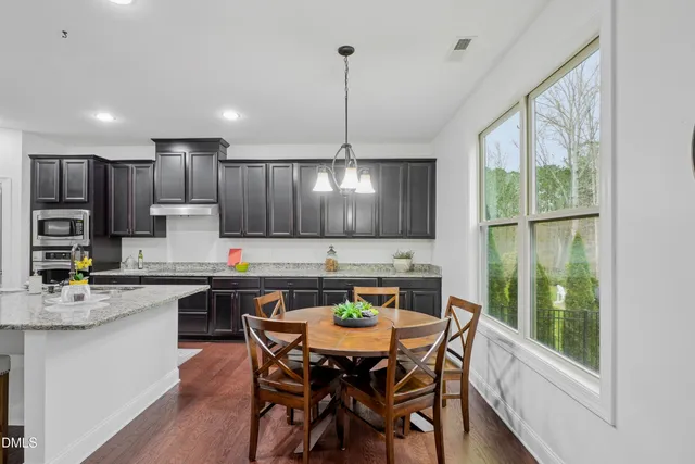 a kitchen with a table chairs sink and cabinets