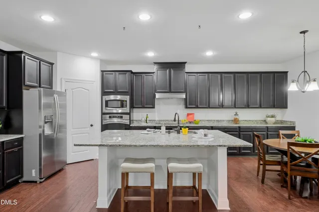 a kitchen with stainless steel appliances granite countertop a stove a sink and a microwave