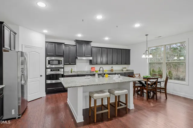 a kitchen with stainless steel appliances granite countertop a sink a stove and a refrigerator