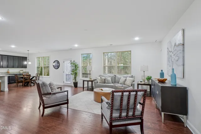 a living room with furniture wooden floor and a large window