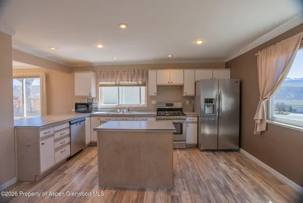 a kitchen with kitchen island a counter top space stainless steel appliances and cabinets