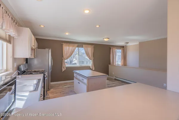 a kitchen with a refrigerator and a stove top oven