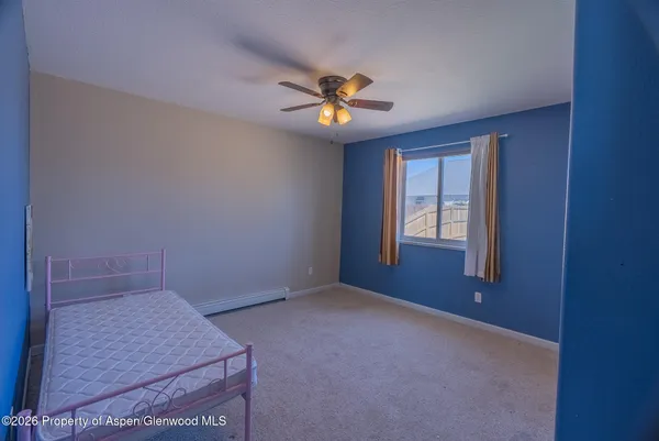 an empty room with windows and fan