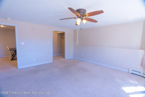 an empty room with closet and fan