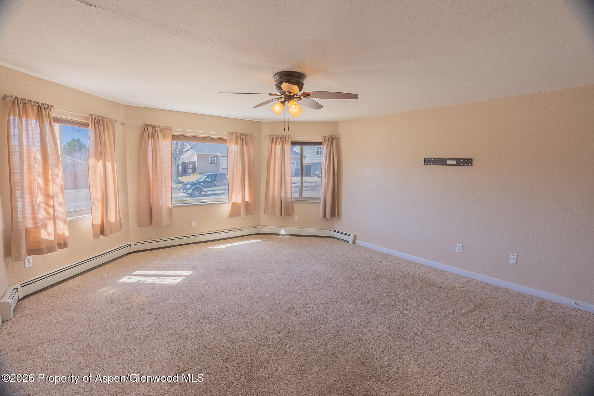 1558 East 12th Street Rifle, CO 81650 - Photo 6 of 25 an empty room with windows and ceiling fan