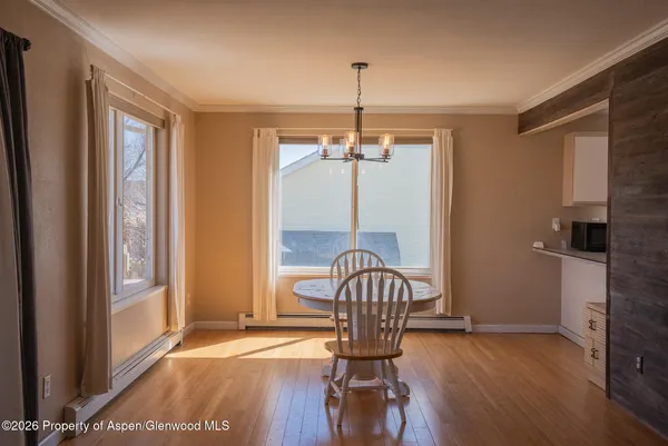 a view of a hallway with wooden floor and dining room view