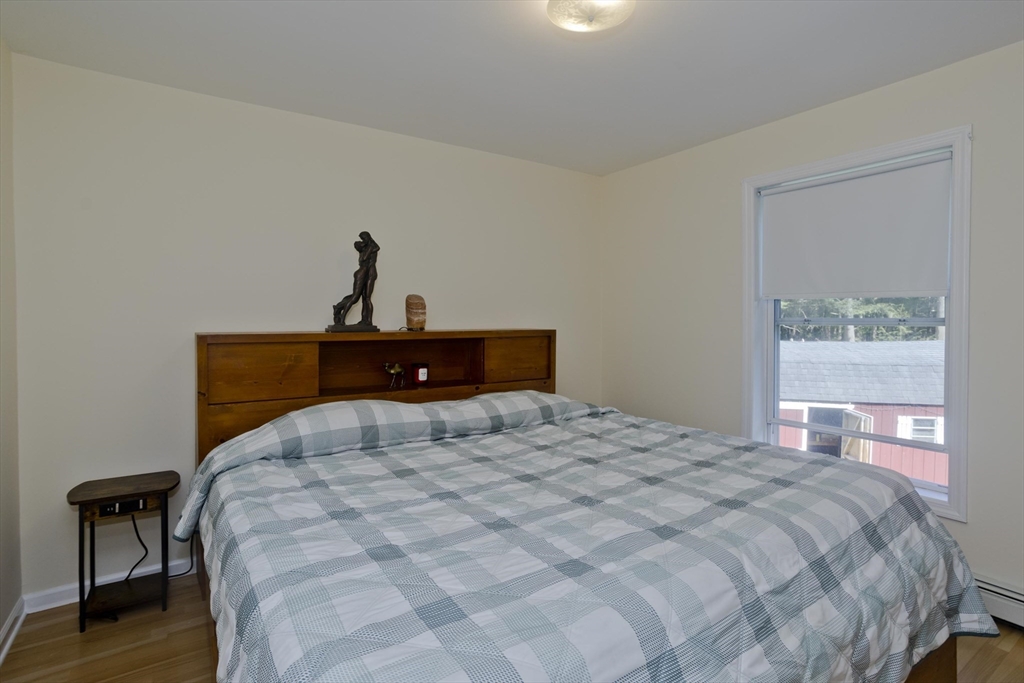 85 Damon Pond Road Chesterfield, MA 01012 - Photo 17 of 42 a bedroom with a large bed and wooden floor
