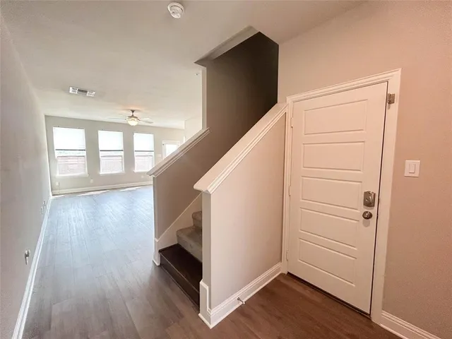 a view of hallway with stairs and wooden floor