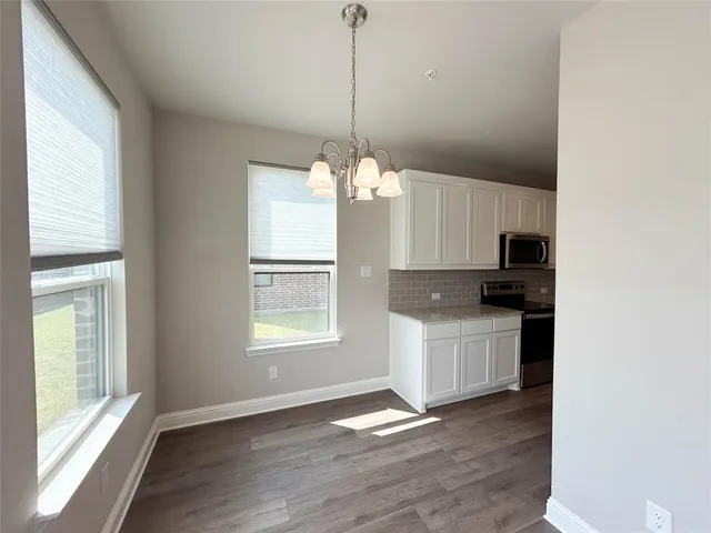 a kitchen with kitchen island granite countertop a stove a sink a window and cabinets
