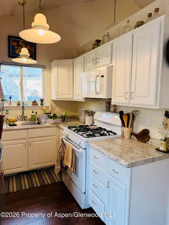 a kitchen with granite countertop a stove sink and cabinets