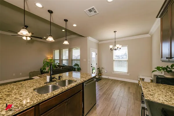 a kitchen with granite countertop a sink stove and wooden floor