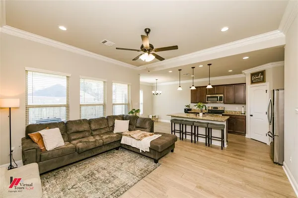 a living room with furniture a wooden floor and a chandelier
