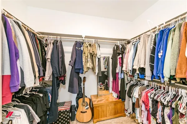 a view of walk in closet with clothes