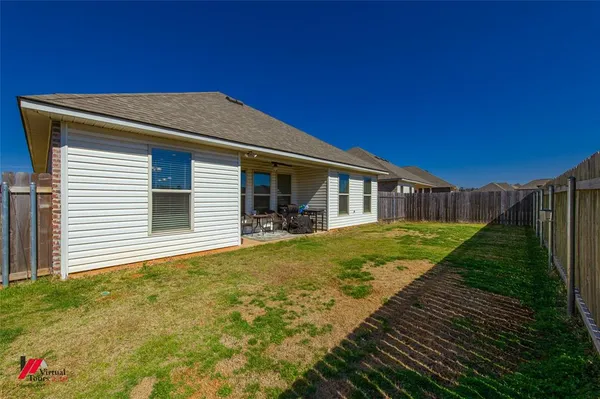 a view of a house with backyard and sitting area