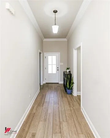 a view of a room with wooden floor and potted plants
