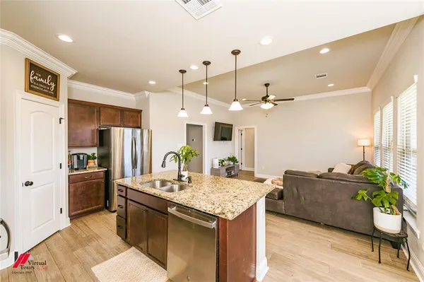 a kitchen with granite countertop a sink cabinets and stainless steel appliances