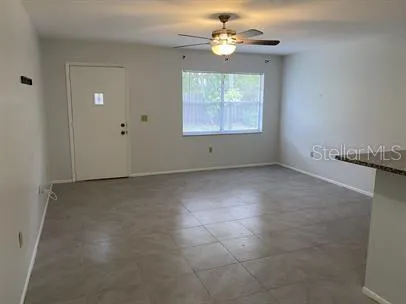 an empty room with windows and fan