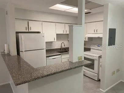 a kitchen with stainless steel appliances granite countertop a refrigerator sink and stove