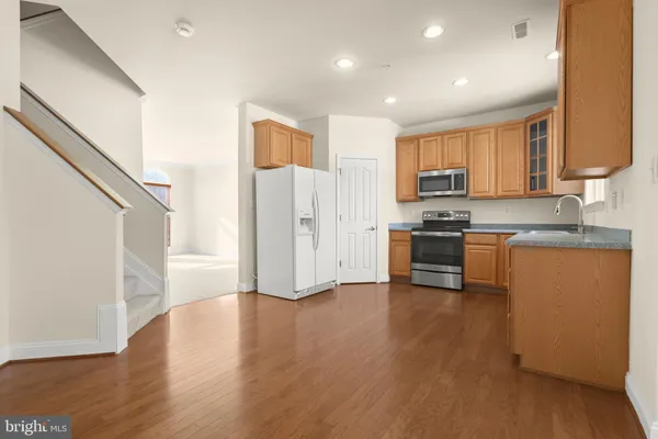 a kitchen with stainless steel appliances a stove a sink a refrigerator and a microwave