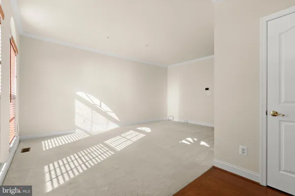 a view of a big room with wooden floor and windows