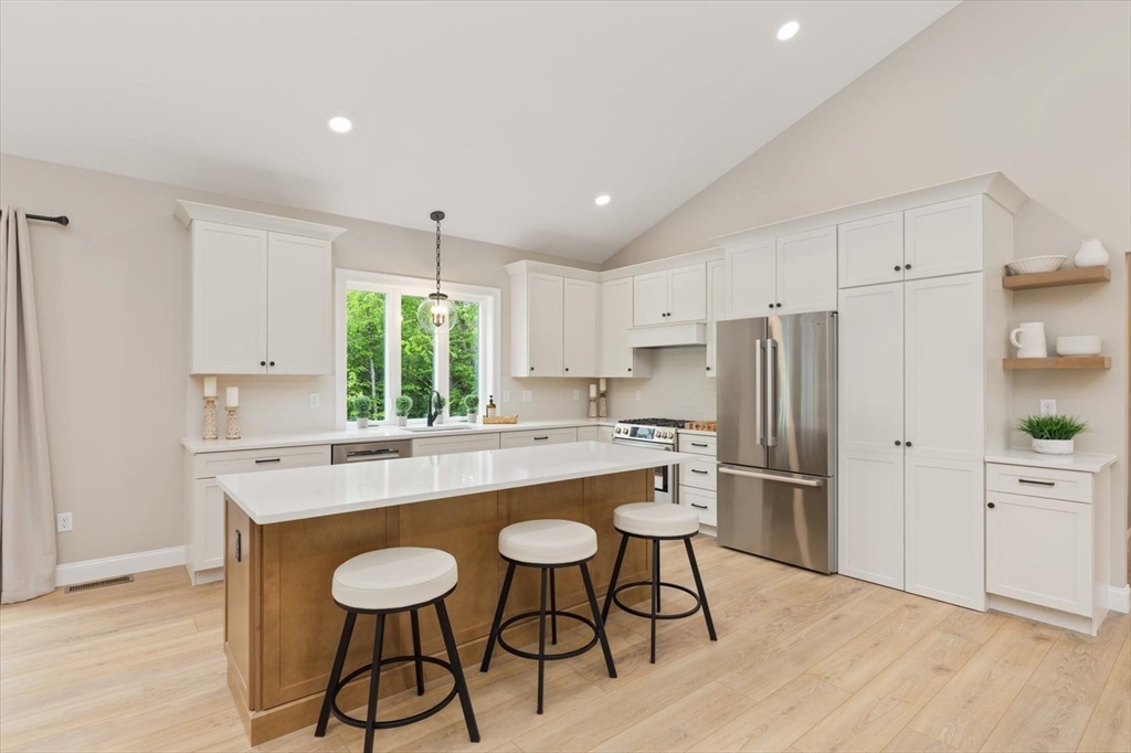 25-2 Sunset Road Westminster, MA 01473 - Photo 16 of 41 a kitchen with stainless steel appliances a dining table chairs refrigerator and cabinets