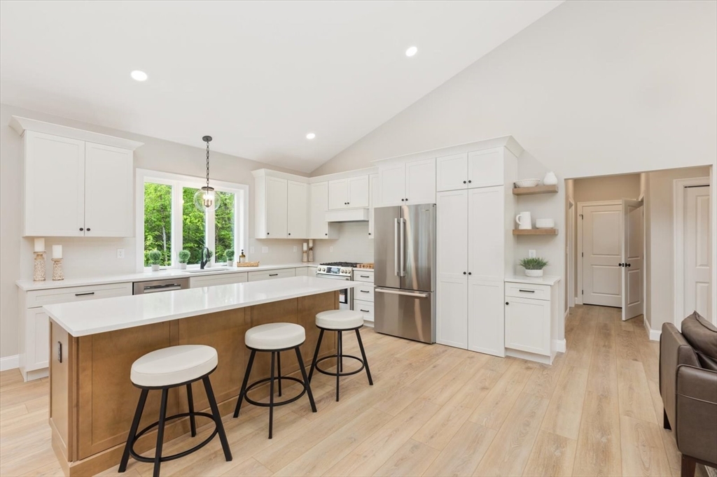 25-2 Sunset Road Westminster, MA 01473 - Photo 17 of 41 a kitchen with stainless steel appliances a dining table chairs refrigerator and sink