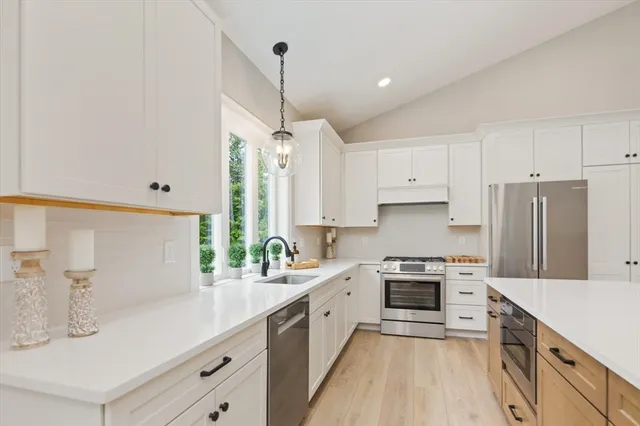 a kitchen with a sink a counter top space stainless steel appliances and cabinets
