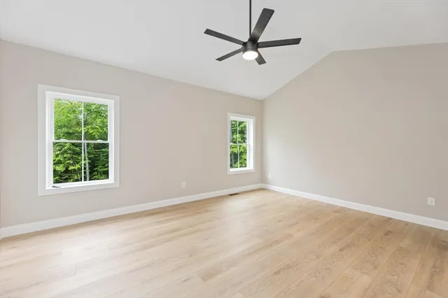 an empty room with window and ceiling fan