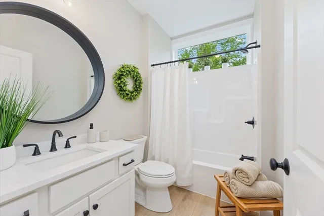 a bathroom with a granite countertop sink mirror vanity and toilet