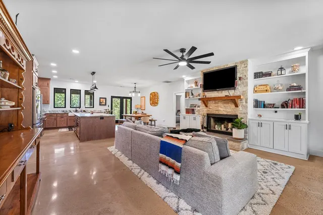 a living room with furniture a fireplace and a chandelier