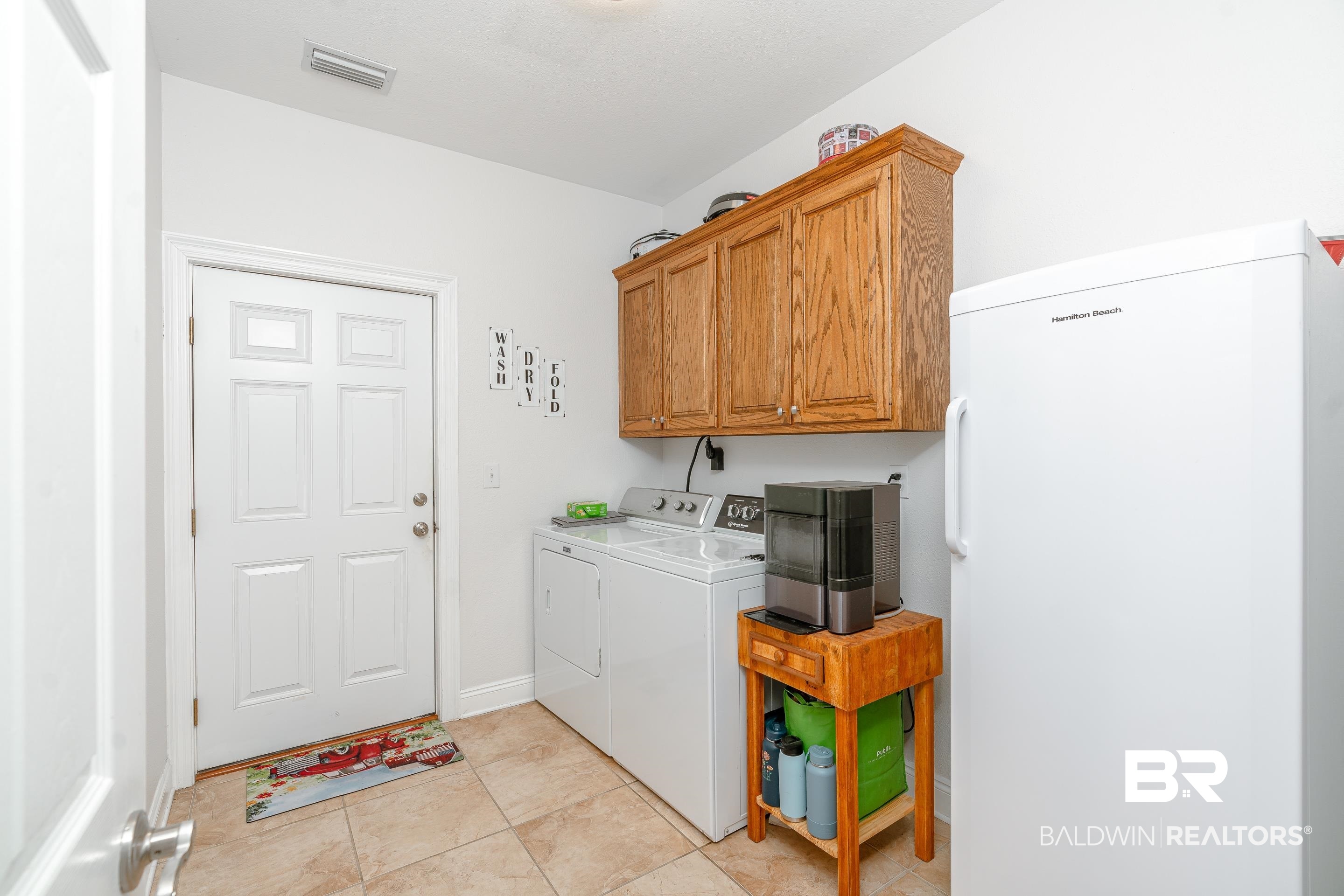 302 Bristol Way Foley, AL 36535 - Photo 26 of 51 Laundry area featuring light tile patterned flooring, independent washer and dryer, and cabinets