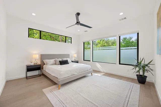 a bedroom with a large bed and a potted plant