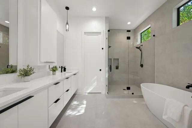 a bathroom with a tub a sink and mirror