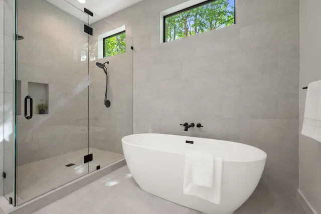 a white bath tub sitting next to a shower