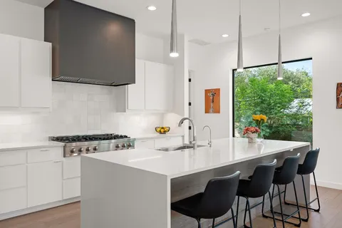 a kitchen with a table chairs sink and cabinets