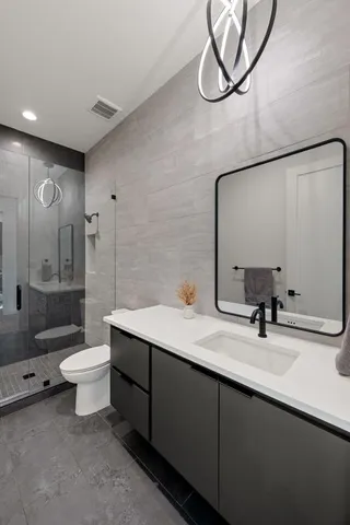a bathroom with a double vanity sink mirror and toilet