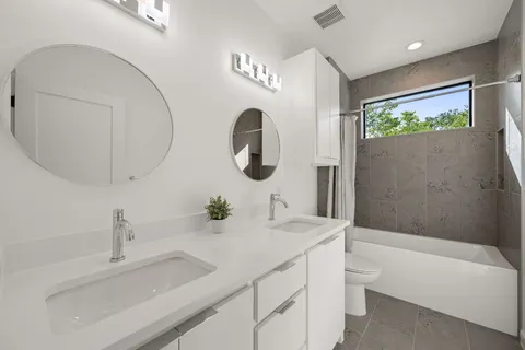 a bathroom with a double vanity sink and a mirror