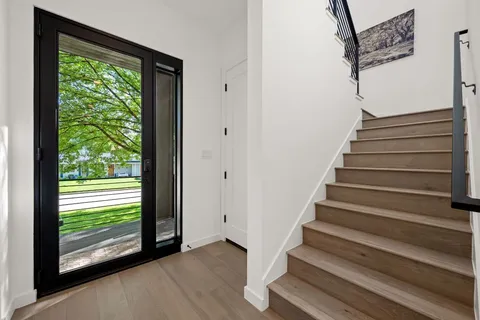 a view of entryway with wooden floor and front door