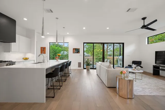 a living room with furniture a flat screen tv and a large window