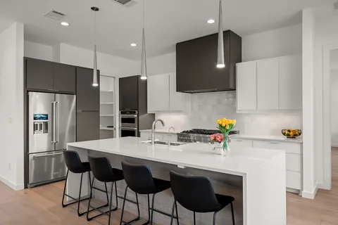 a kitchen with stainless steel appliances kitchen island granite countertop a sink refrigerator and cabinets